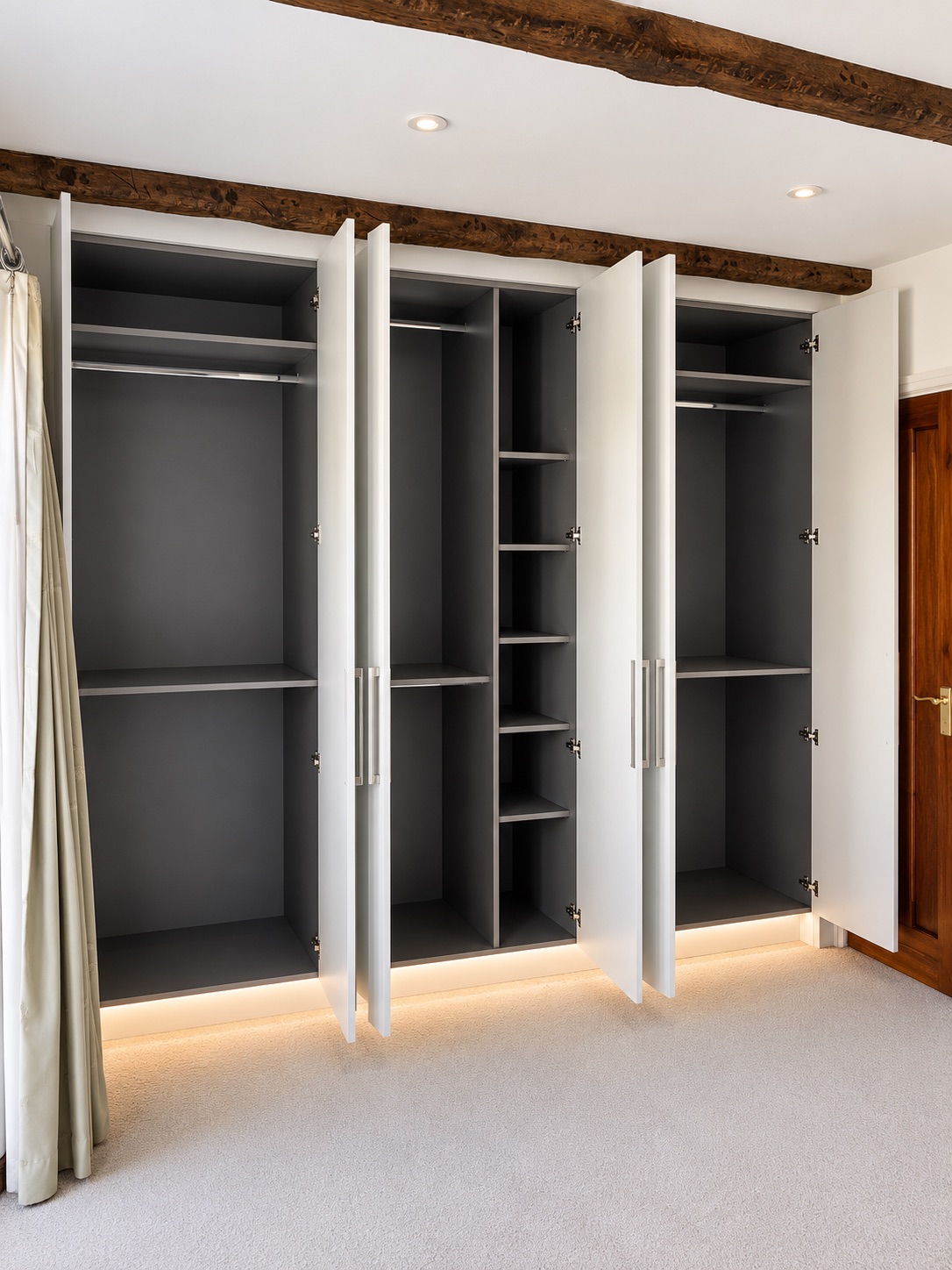 Open fitted wardrobes in Basildon showing Anthracite Linen interiors, hanging rails and adjustable shelves