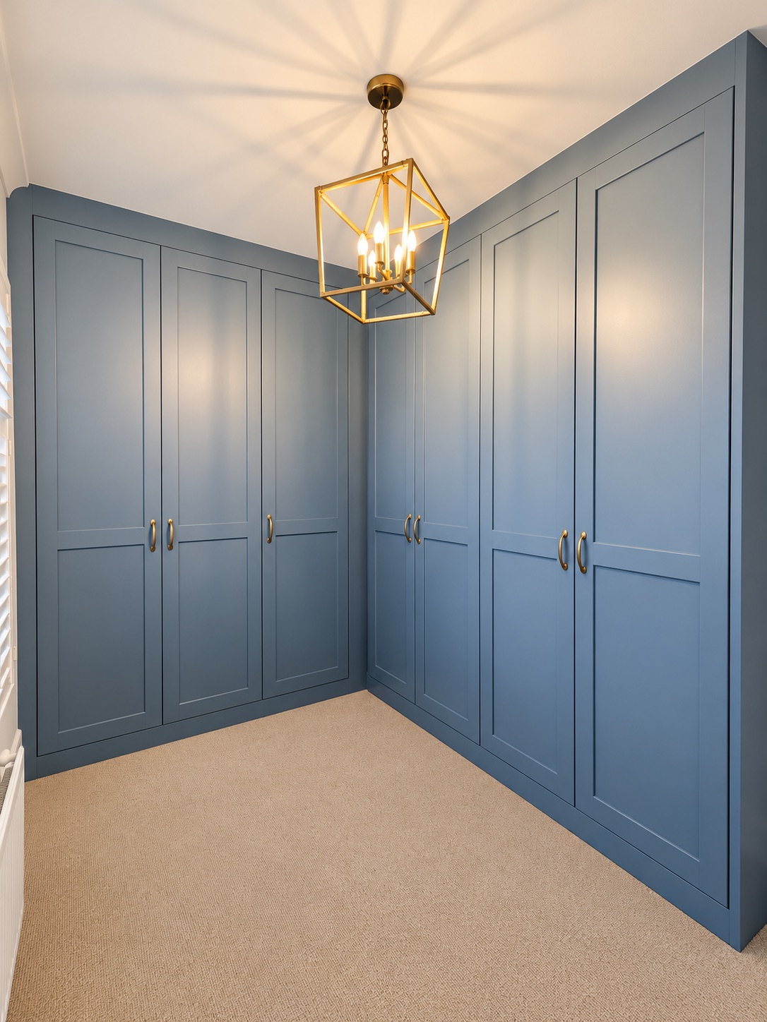 Blue Vein painted L-shaped walk-in fitted wardrobes in a Southend dressing room