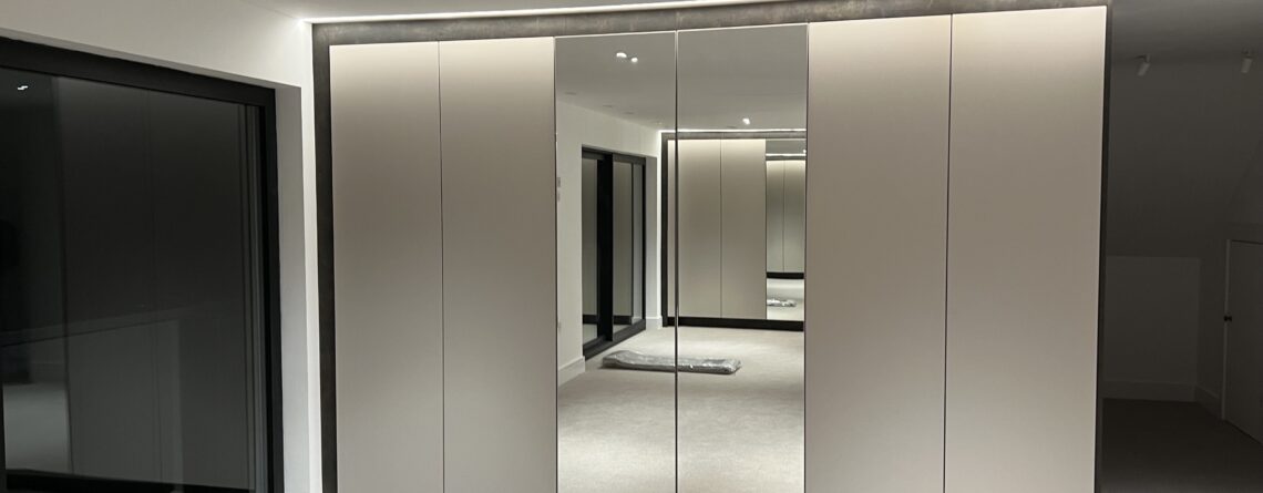 Bespoke fitted in wardrobes with mirrored panels and custom storage solutions.