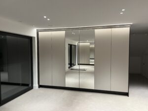 Bespoke fitted in wardrobes with mirrored panels and custom storage solutions.